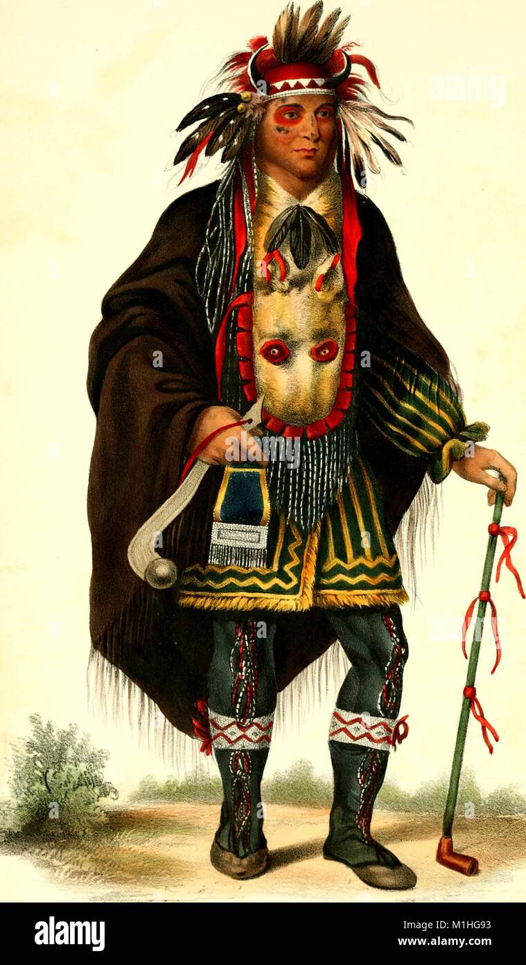 Volle Länge, Farbe Abbildung: chippeway Chief Okeemakeequid, das Tragen der roten und schwarzen Gesicht Farbe, eine aufwändige Perlen und gefiederten Sioux Outfit, mit Kopfbedeckung, Stiefeln und Umhang, über eine gestreifte Jacke, einer durchgehenden Hip Bag, und Hals umschlang Tierkopf Beutel, und halten einen Club in der einen Hand und eine lange Leitung in den anderen, aus dem Buch "Indischen Lebenslauf" von Thatcher BB (Benjamin Bussy), 1825 verfasst. Mit freundlicher Genehmigung Internet Archive. () Stockfoto