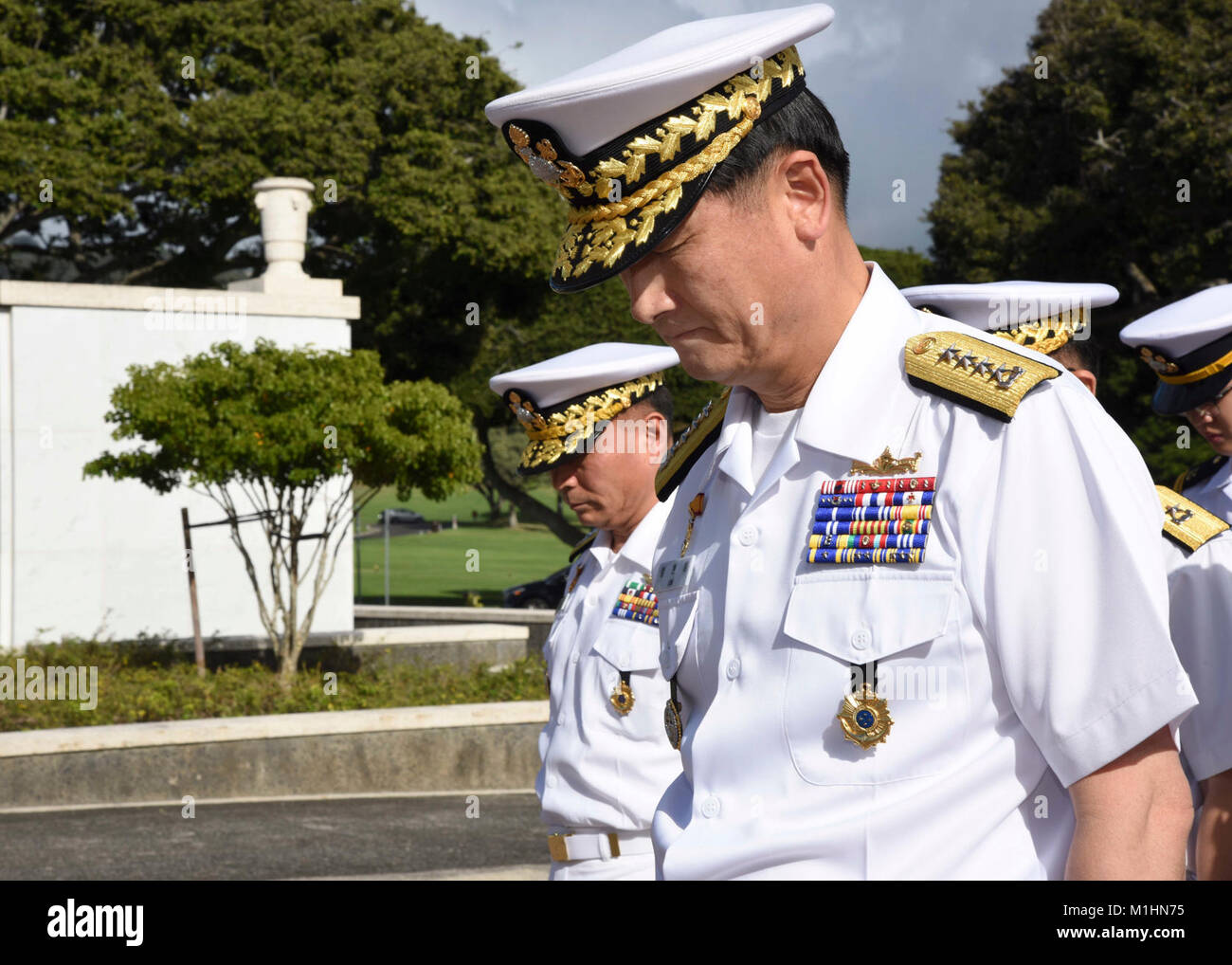 HONOLULU (Jan. 25, 2018) Adm. Hyun-seong, ähm, Center, Republik Korea Leiter der Marine, Bögen in Bezug während einer Kranzniederlegung Zeremonie am National Memorial Friedhof des Pazifik. Adm. Um ist zu einem zweitaegigen Besuch in Oahu, Hawaii, Treffen mit US-Militärs im Pazifik. (U.S. Marine Stockfoto