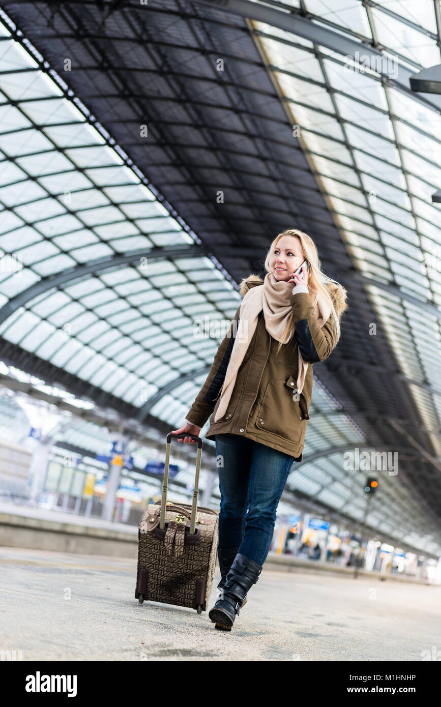 Frau mit ihrem Gepäck zu Fuß entlang der Plattform in Zug Stati Stockfoto
