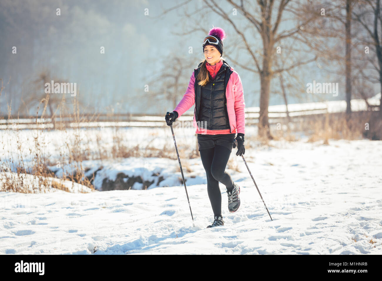 Passende Frau Nordic Walking im Winter Landschaft Stockfoto