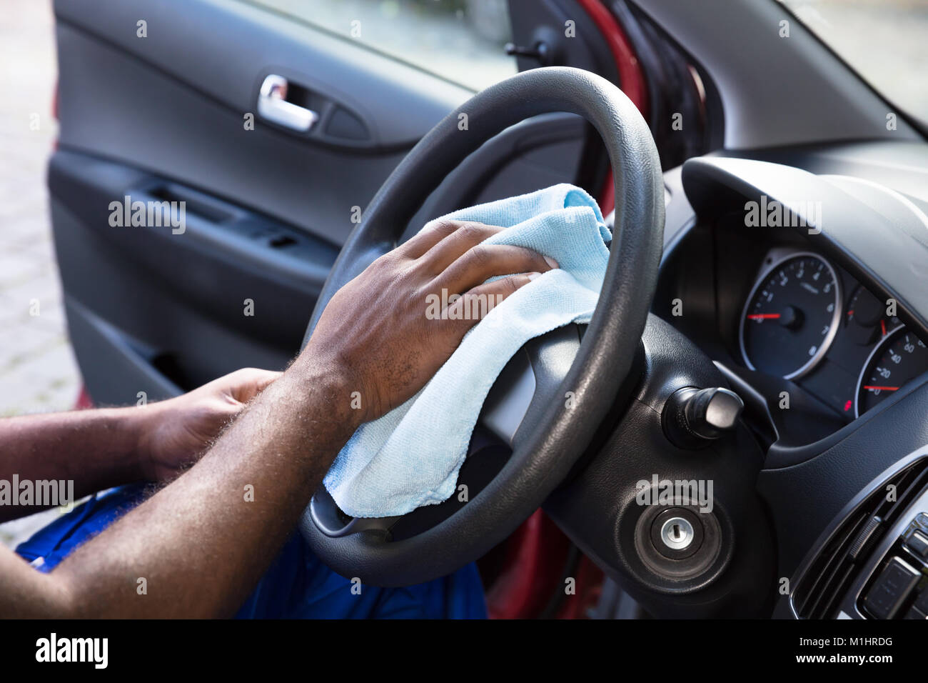 Nahaufnahme der Person Hand Reinigung Auto Lenkrad mit Tuch Stockfoto