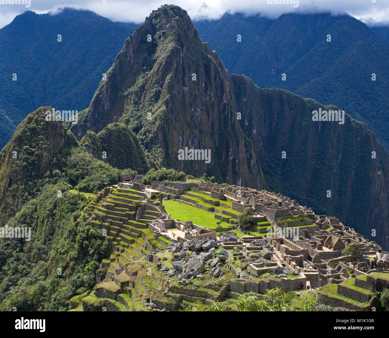 Machu Picchu Klassiker schoß mit bedecktem Himmel, aber die Sonne auf der Website. Einen sehr guten Kontrast. Stockfoto