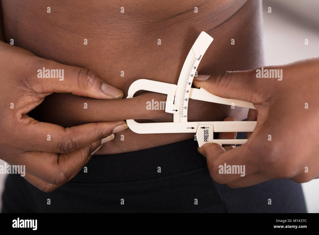 Close-up aus einer menschlichen Hand messen Bauch Fett mit Bremssattel Stockfoto