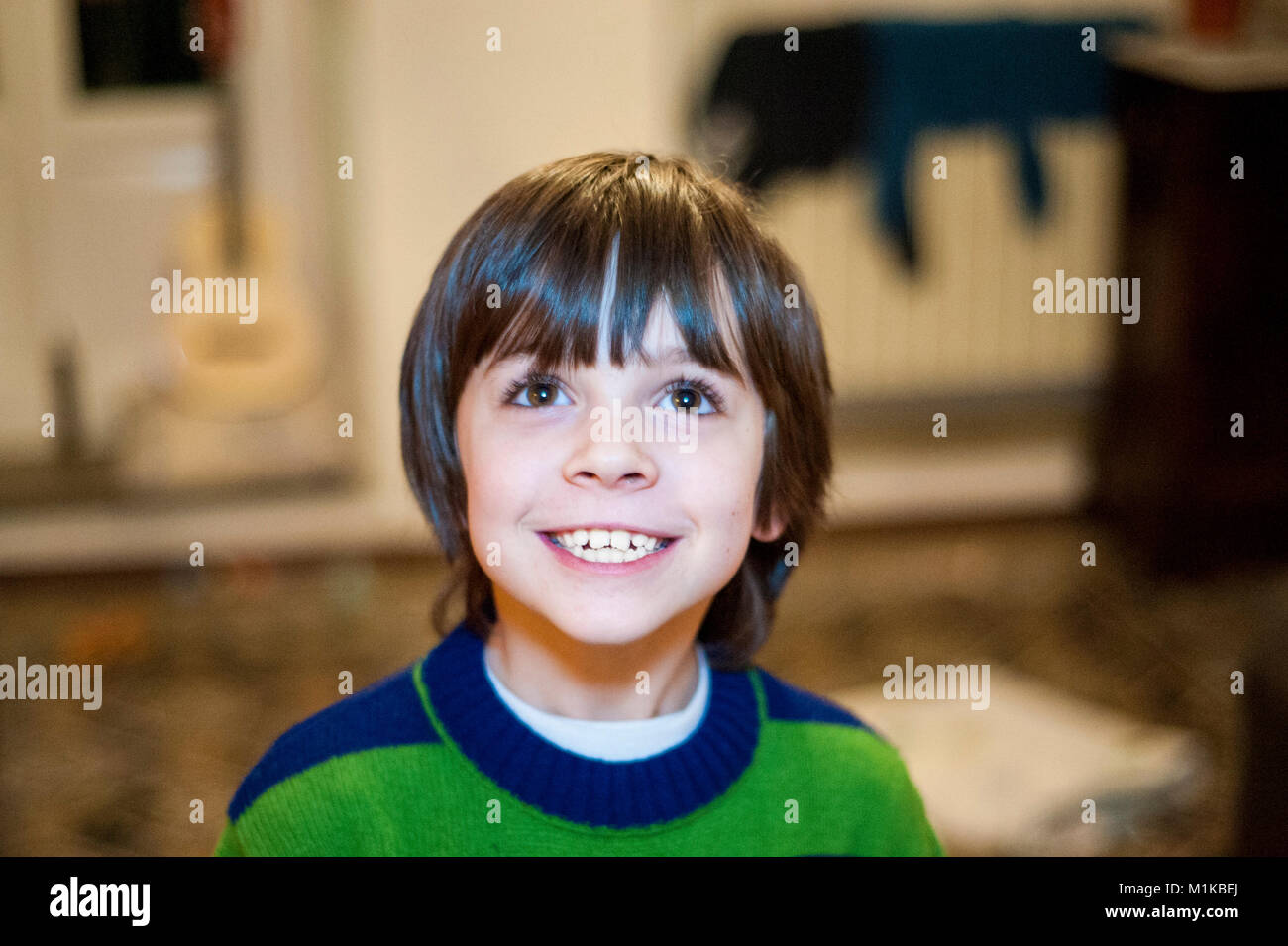 Portrait von 10 Jahre alten Jungen in seinem Haus lächelnd nach oben Stockfoto