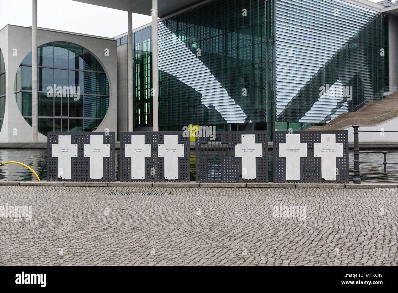 Memorial Kreuze zum Gedenken an die Opfer der Berliner Mauer an der Spree mit neben dem modernen Gebäuden der deutschen Regierung in den Hintergrund. Stockfoto