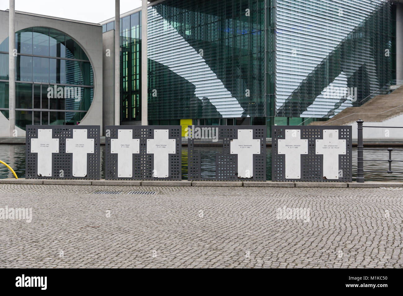 Memorial Kreuze zum Gedenken an die Opfer der Berliner Mauer an der Spree mit neben dem modernen Gebäuden der deutschen Regierung in den Hintergrund. Stockfoto