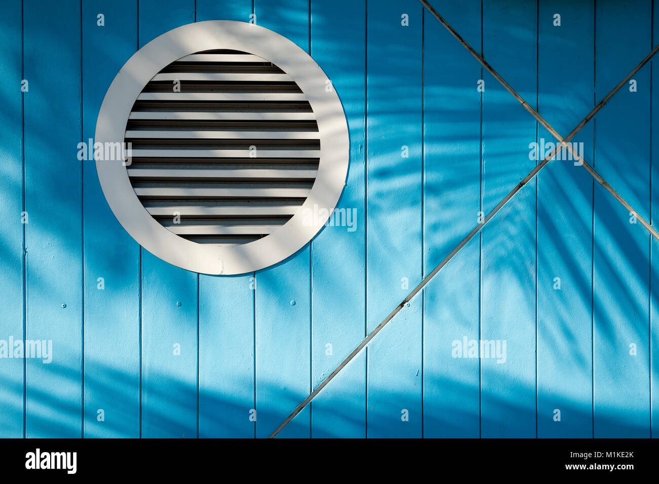 Strukturierten Hintergrund der tropischen Palme Wedel Schatten winken in helle Sonne über hell blau im nautischen Thema Wand Stockfoto