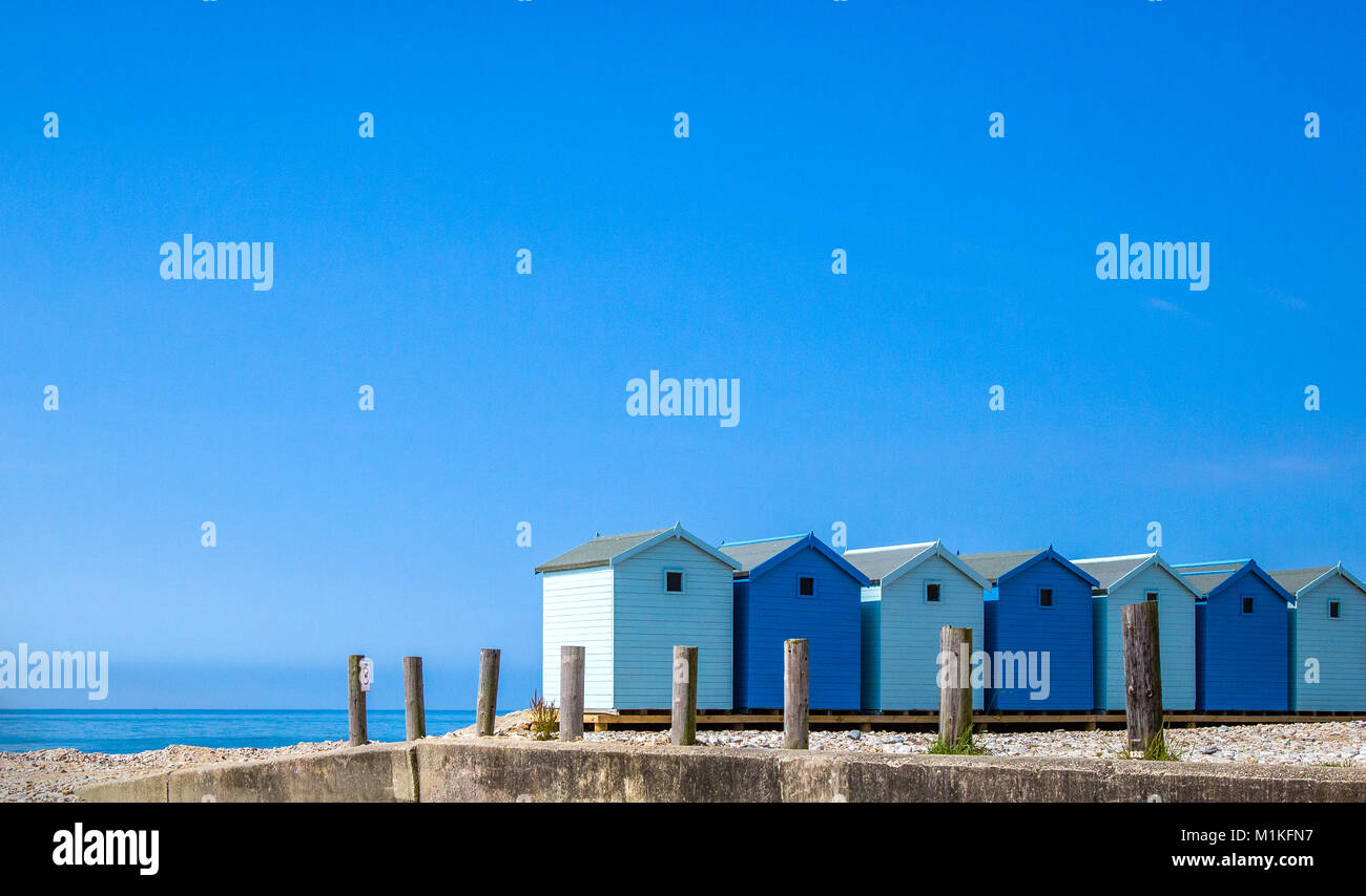 Strandhütten in Blau am Strand von Charmouth, Dorset UK Stockfoto