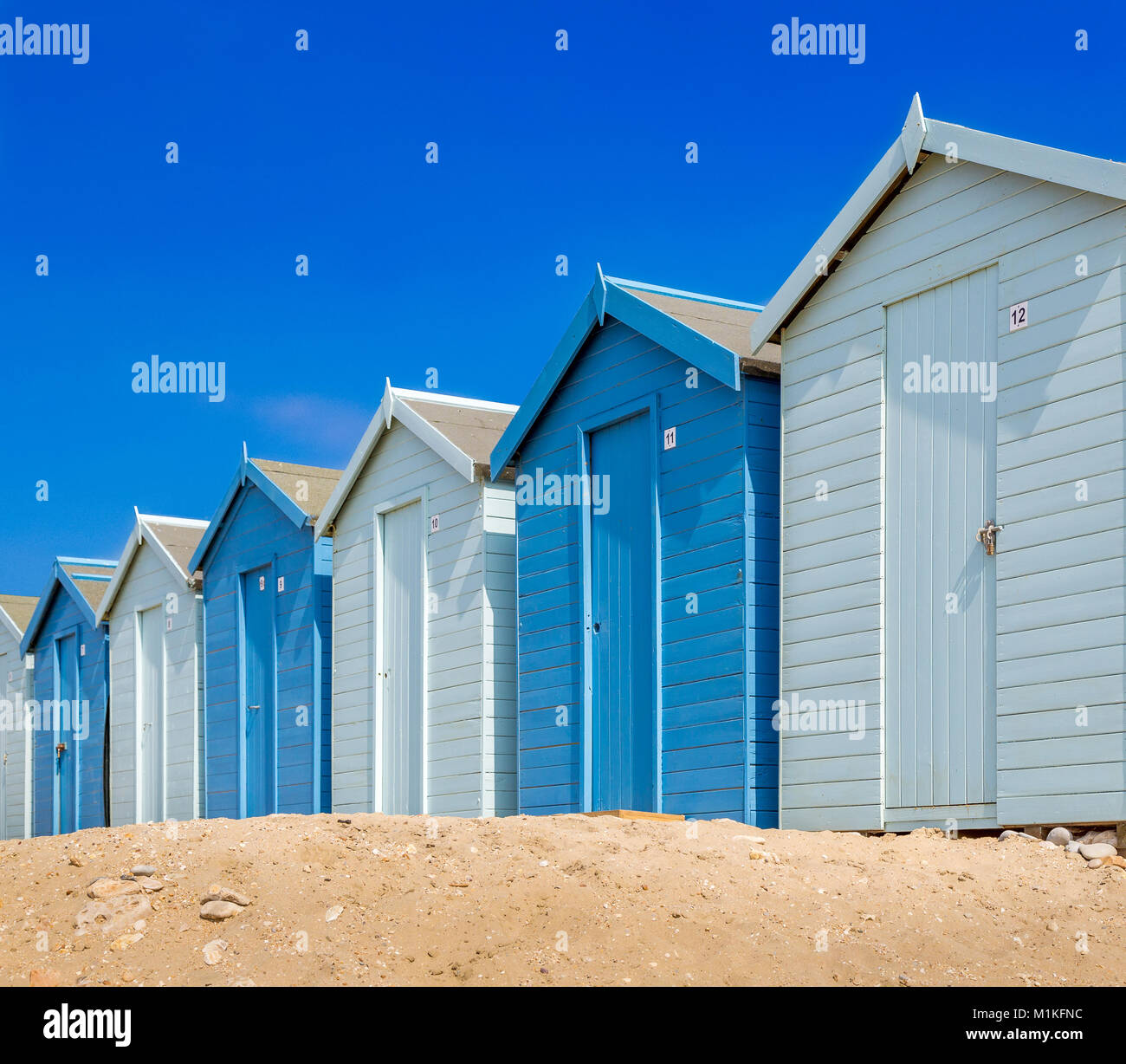 Strandhütten in Blau am Strand von Charmouth, Dorset UK Stockfoto