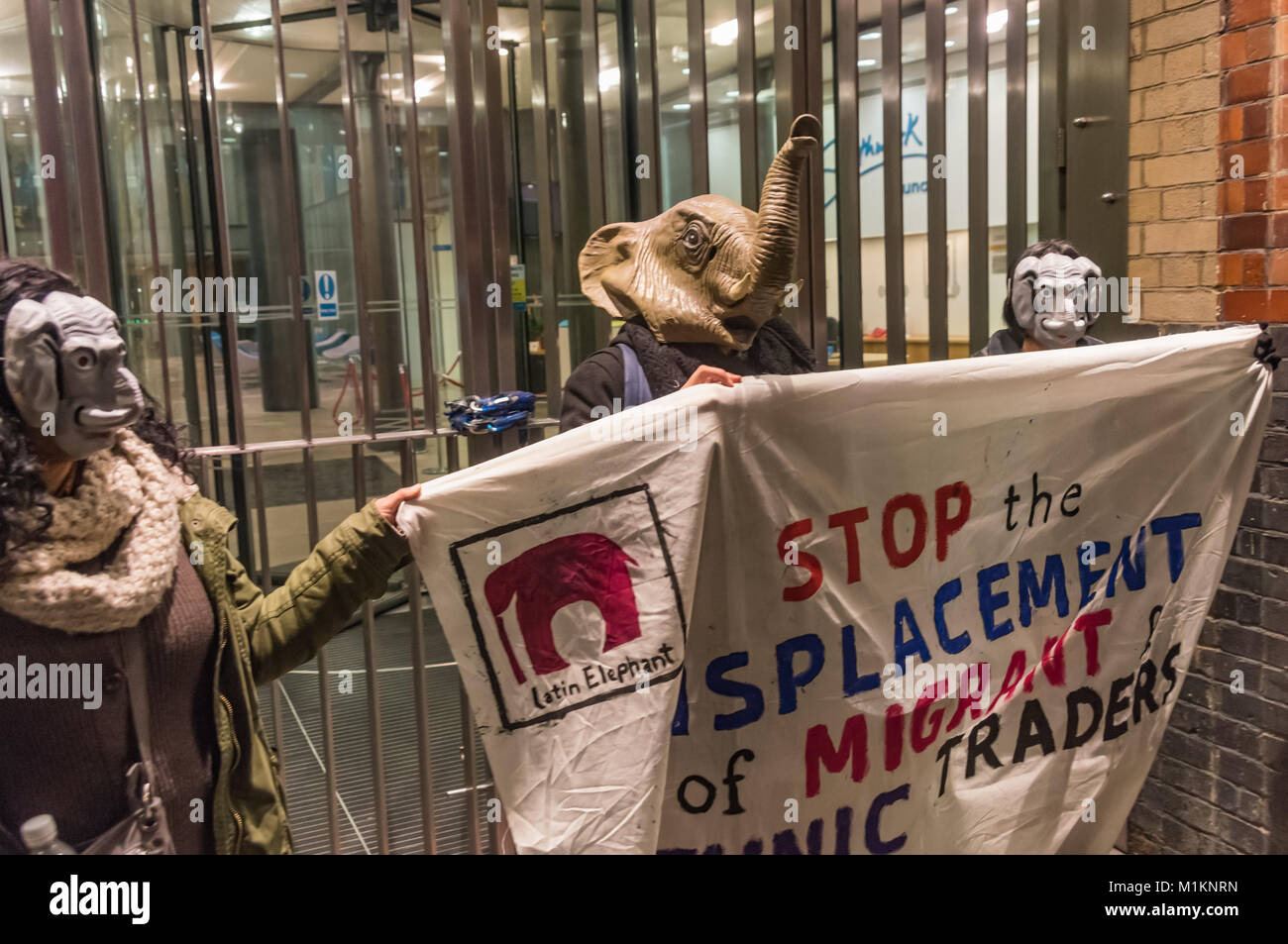 London, Großbritannien. 30. Jan 2018. Demonstranten in Elephant Masken halten ein Banner gegen Verdrängen von Migranten und ethnischen Händler. Es gab reden, Tanzen und Bingo außerhalb der Southwark Sitzung des Rates, wurde nach Plänen von Entwickler Delancey und den Rat, in dem Elephant & Castle Center und die Gemeinschaft um ihn herum zerstören würde zu stimmen. Das Zentrum verfügt über eine Bingo Halle und ist das Herz einer lebendigen Lateinamerikanischen Gemeinschaft. Credit: Peter Marschall/Alamy leben Nachrichten Stockfoto