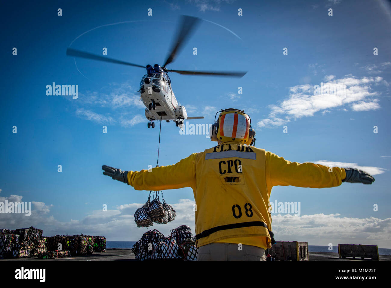 Pazifik (Jan. 26, 2018) Chef der Luftfahrt Bootsmann Mate (Handling) Anthony weißen Signale eine SA-330 Puma Helikopter für die Trockenschiffahrt und Munition ship USNS Wally Schirra (T-AKE 8) Während eine Auffüll-anforderung auf See mit der nimitz-Klasse Flugzeugträger USS Carl Vinson (CVN 70). Die Carl Vinson Carrier Strike Group ist in den Pazifischen Ozean als Teil einer regelmäßigen Bereitstellung. (U.S. Marine Stockfoto