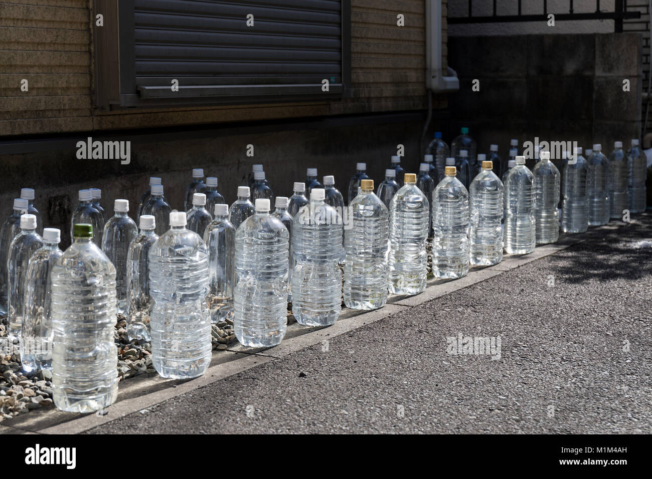 Nekoyoke, mit Wasser gefüllte PET-Flaschen, die Katzen fernhalten sollen; Suginami, Tokio, Japan Stockfoto