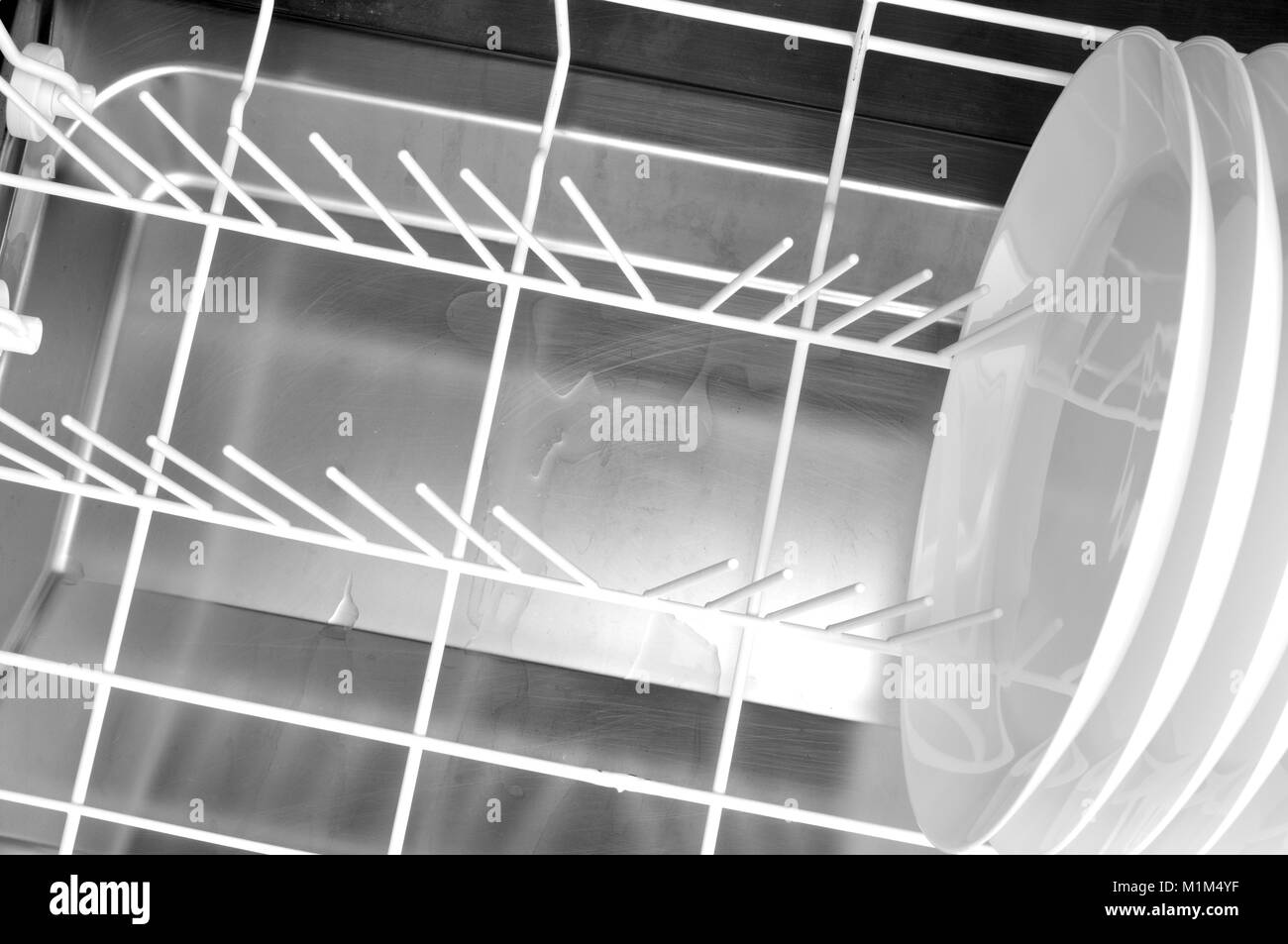 Geschirr aus der Spülmaschine zu entfernen, ziehen Sie an der Spülmaschine Korb mit ein paar sauberes Geschirr schließen Stockfoto