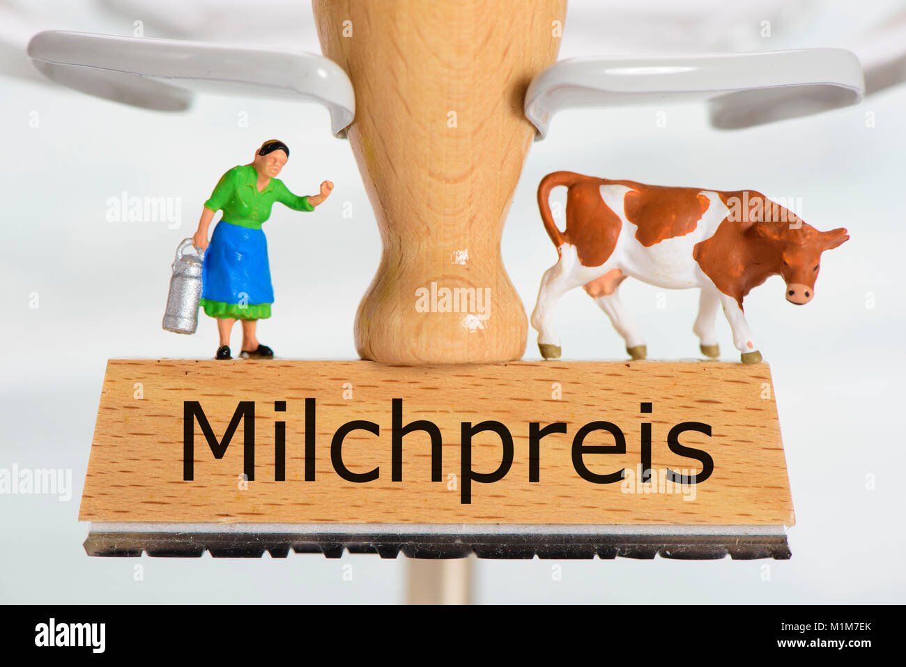 Milchpreis in Holzstempel mit Bäuerin und Milchkuh Stockfoto