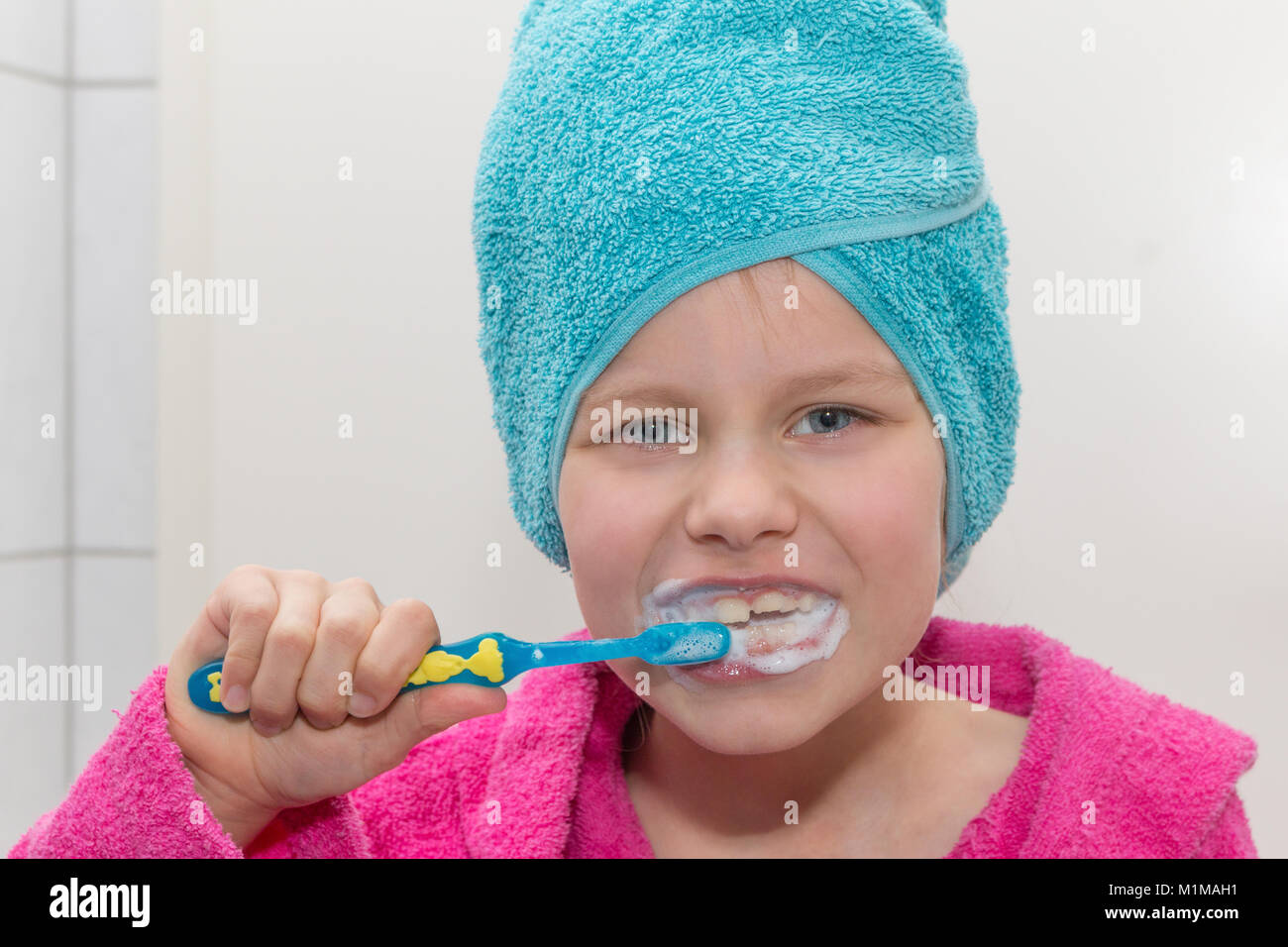 Ein 6 Jahre altes Mädchen Bürsten ihre Zähne und lächelt, Porträt Stockfoto