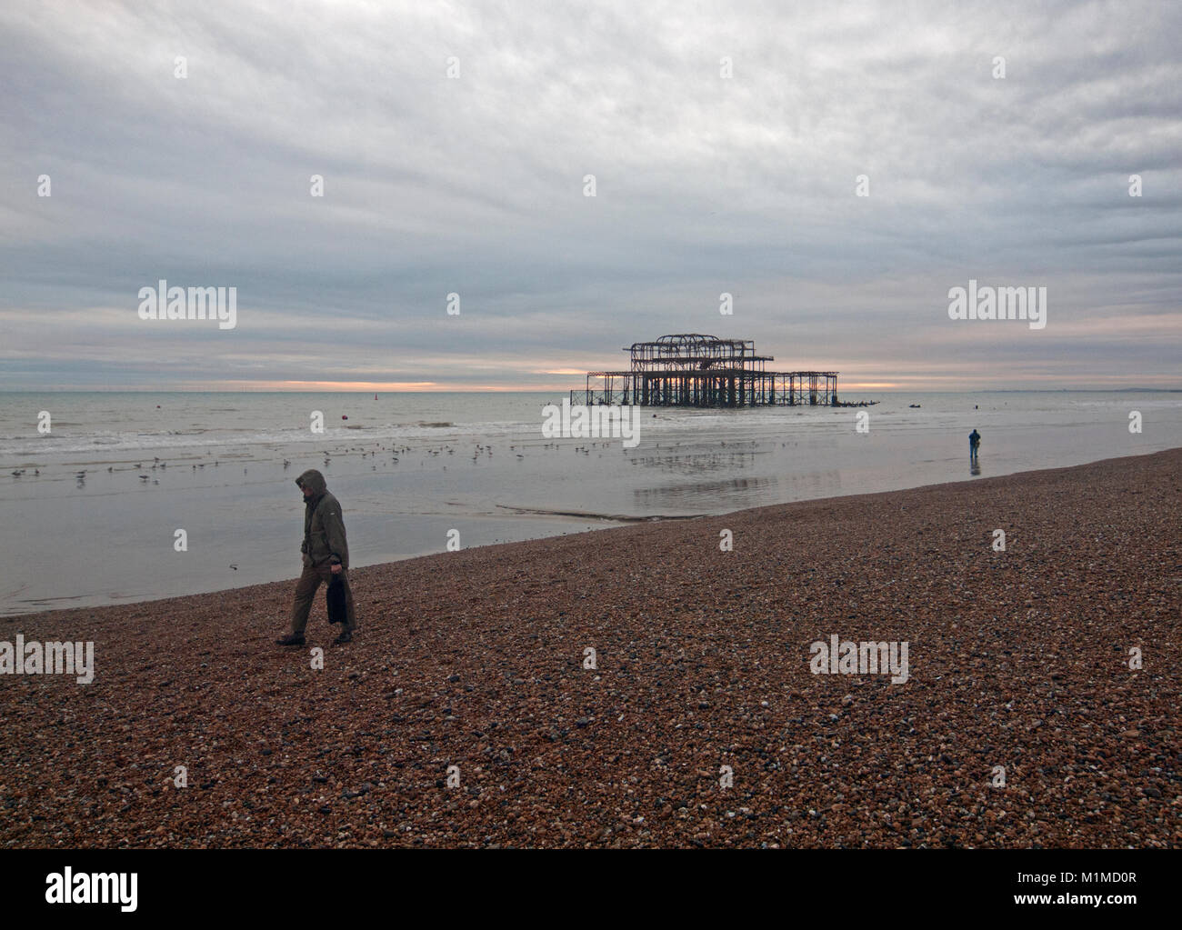 Eine einsame Figur in der Nähe der Old West Pier in Brighton Stockfoto