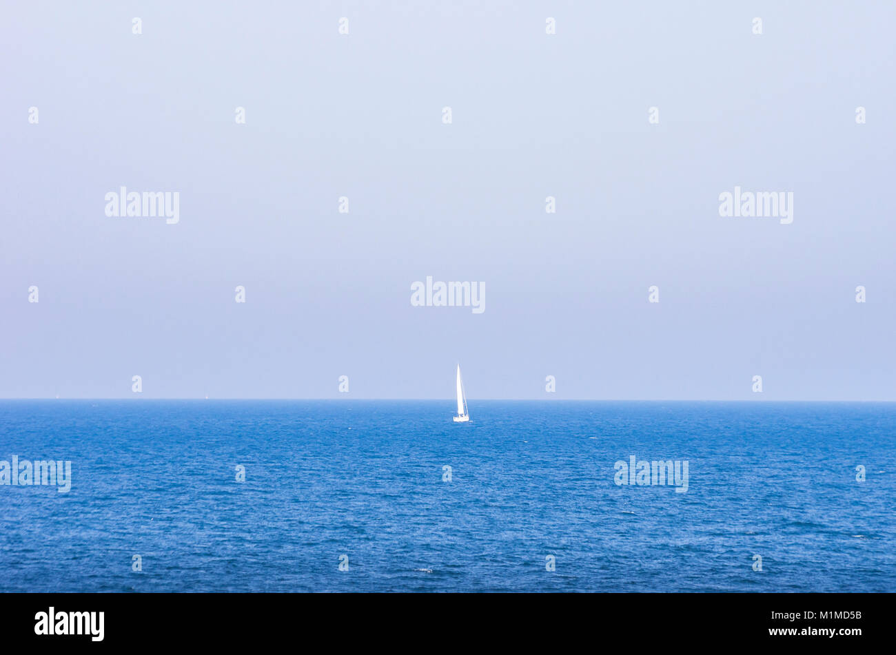 Kleines Segelboot am Horizont auf offener See. Stockfoto