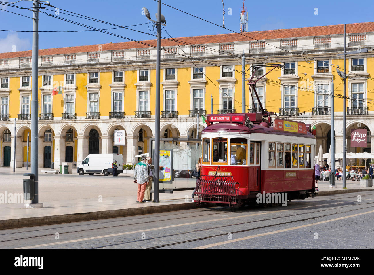 Die rote iconic Classic elektrische Straßenbahn an einer Straßenbahnhaltestelle in Praça do Comércio mit täglichen Verkehr, Lissabon, Portugal Stockfoto