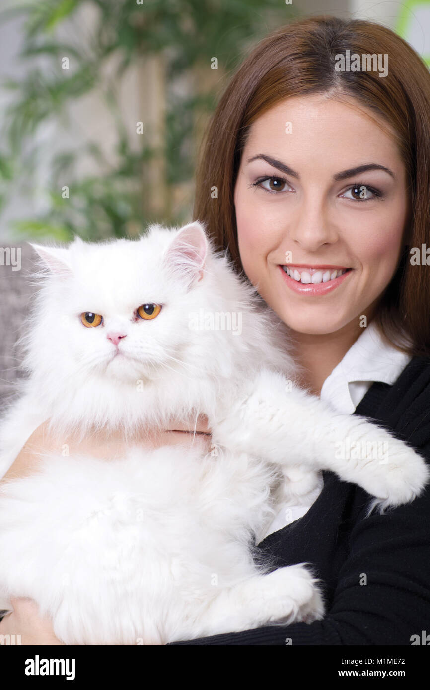 Mädchen umarmt einen weißen Perser Katze Stockfoto