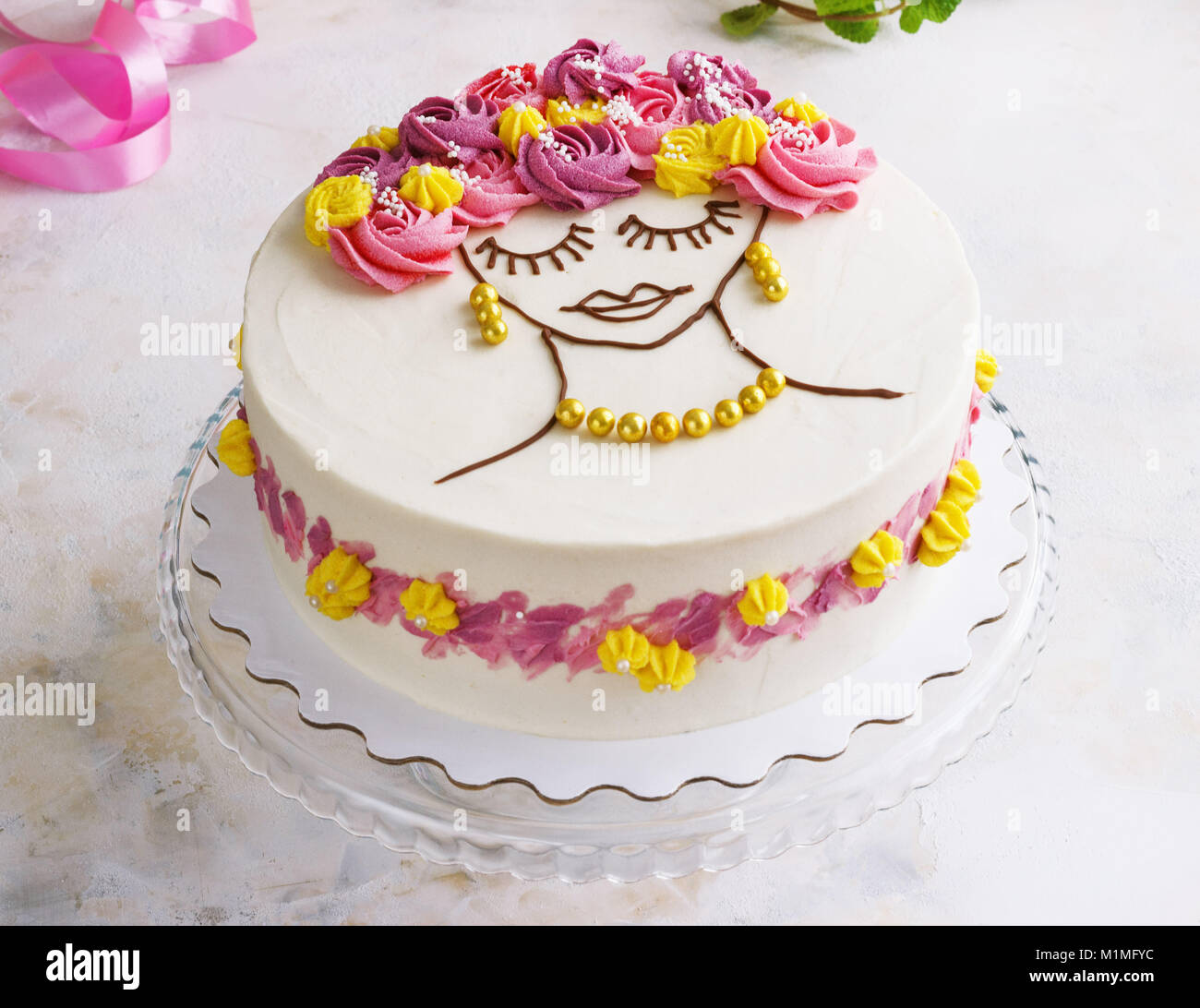 Festliche Kuchen mit Sahne Blumen und ein Mädchen Gesicht auf einen hellen Hintergrund Stockfoto