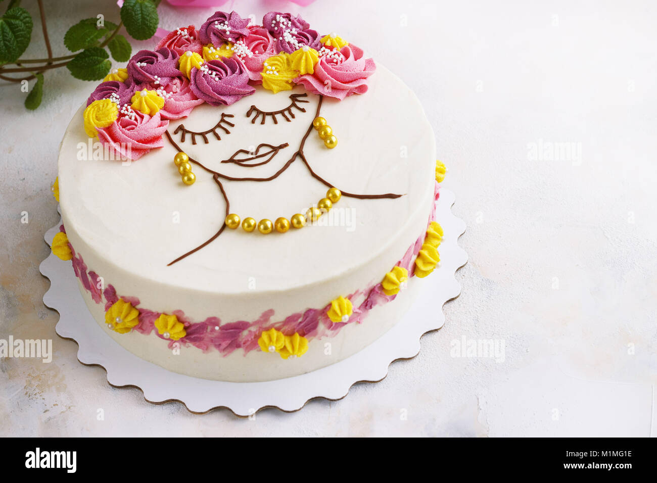Festliche Kuchen mit Sahne Blumen und ein Mädchen Gesicht auf einen hellen Hintergrund Stockfoto
