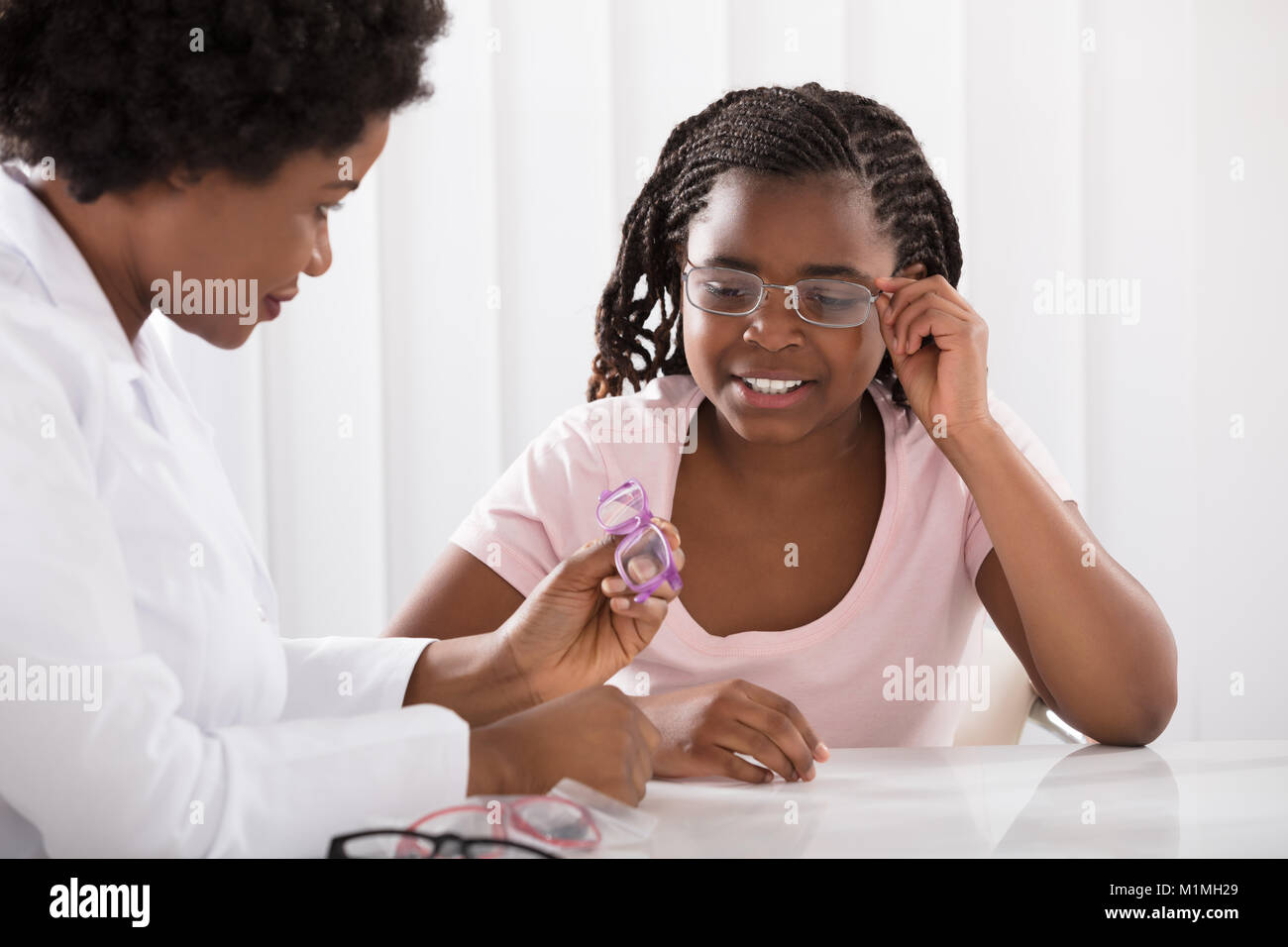 Nahaufnahme einer Optiker helfen Mädchen Brillen zu wählen Stockfoto