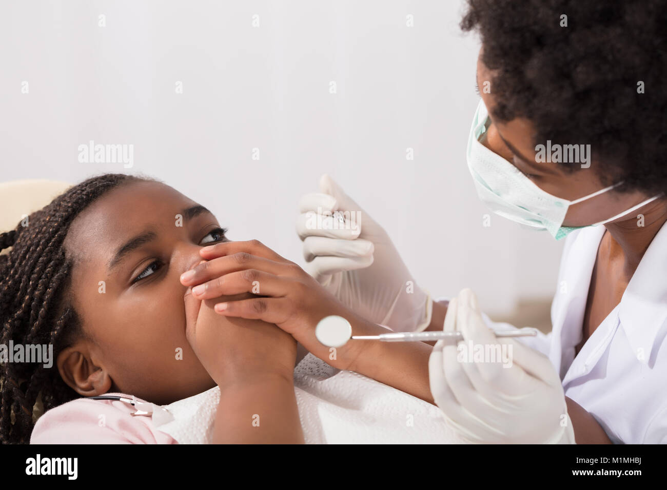 Angst Mädchen, die Ihren Mund mit den Händen an Zahnarzt Stockfoto