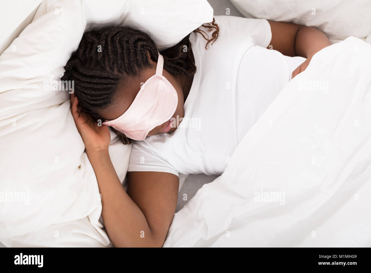 Nahaufnahme einer afrikanischen Mädchen mit rosa Augenmaske im Bett schlafen Stockfoto
