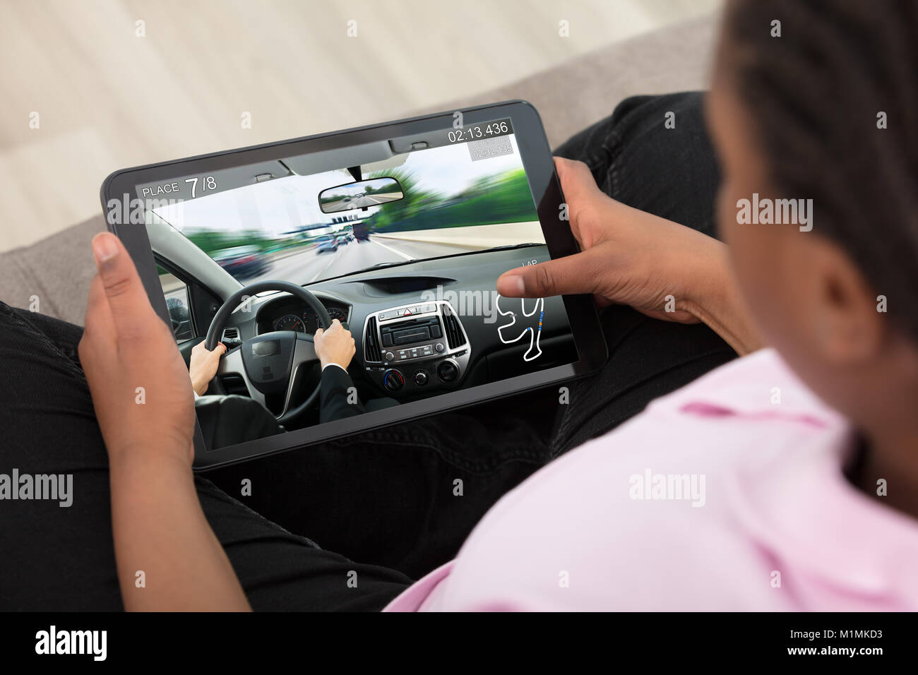 Erhöhten Blick auf ein Mädchen spielen, Autorennen Spiel auf Digital Tablet Stockfoto