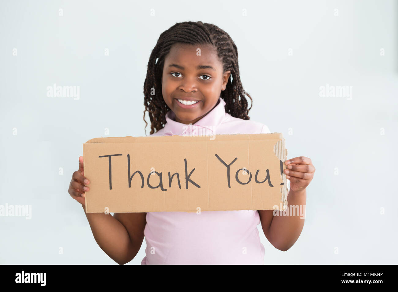 Close-up mit einem lächelnden Afrikanische Mädchen, dass Vielen Dank, dass Sie sich gegen den weißen Hintergrund Stockfoto