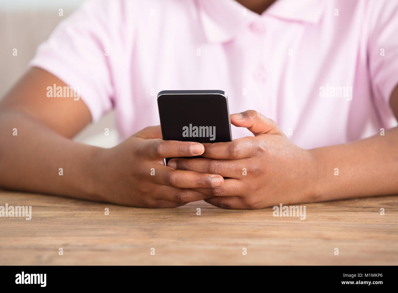 Close-up ist ein Mädchen Hand auf Tabelle mit Smart Phone Stockfoto