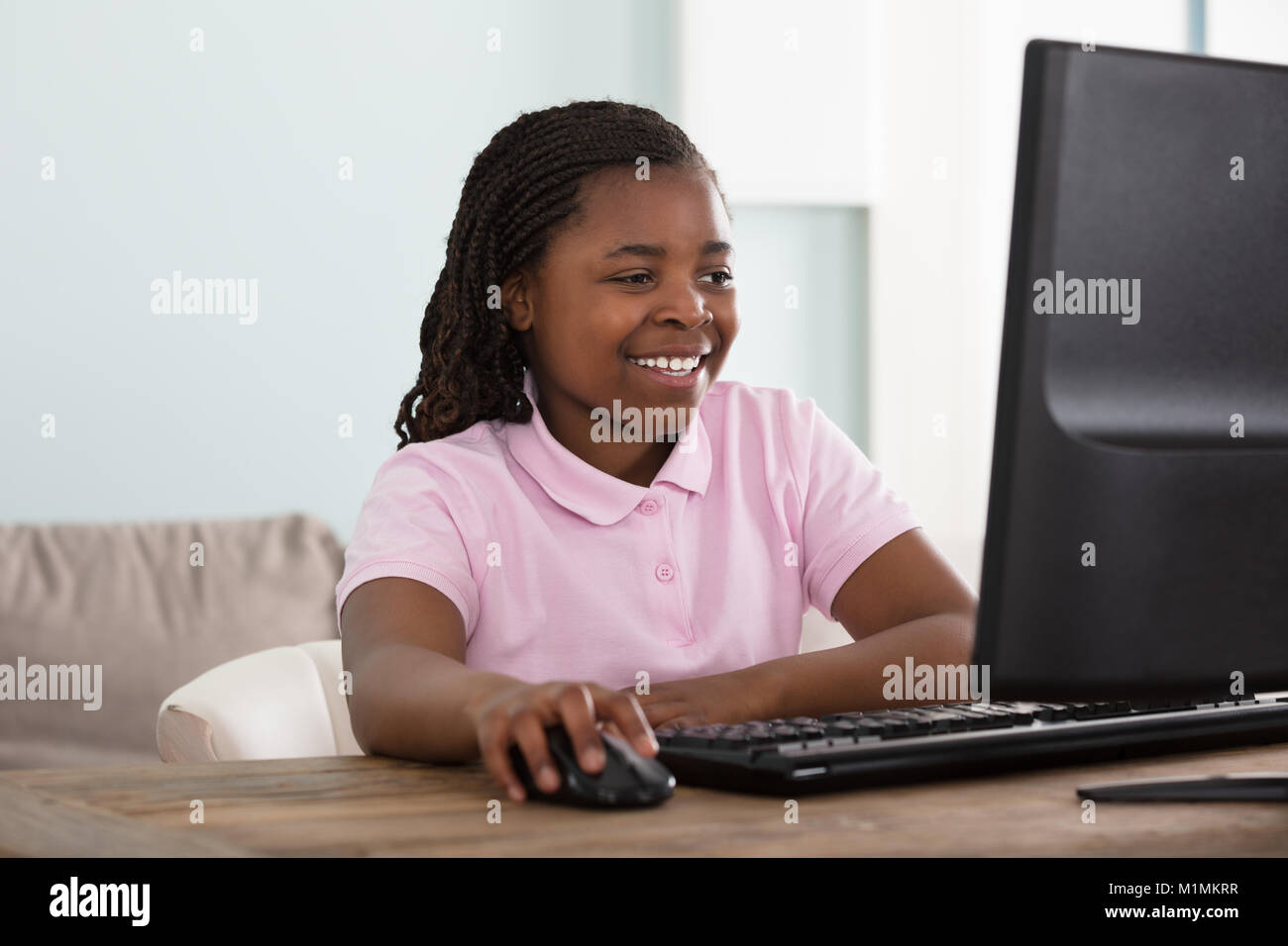 Porträt eines Afrikanischen lächelnde Mädchen mit Computer zu Hause. Stockfoto