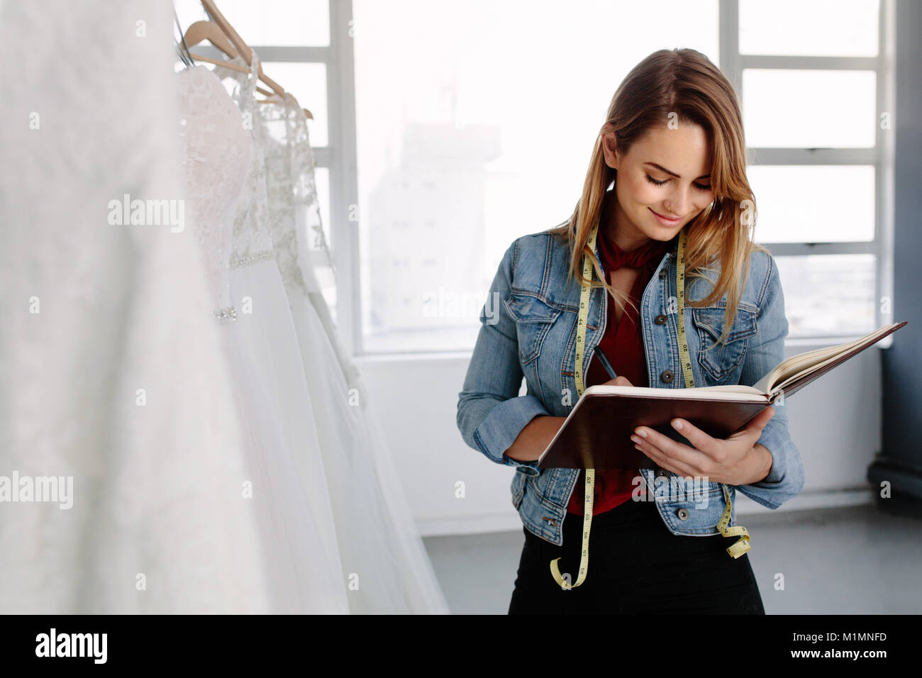 Weibliche Mode Designer arbeiten in der Brautmode speichern und Schreiben in ein Tagebuch. Weibliche Bridal store Owner in Ihrer Boutique. Stockfoto
