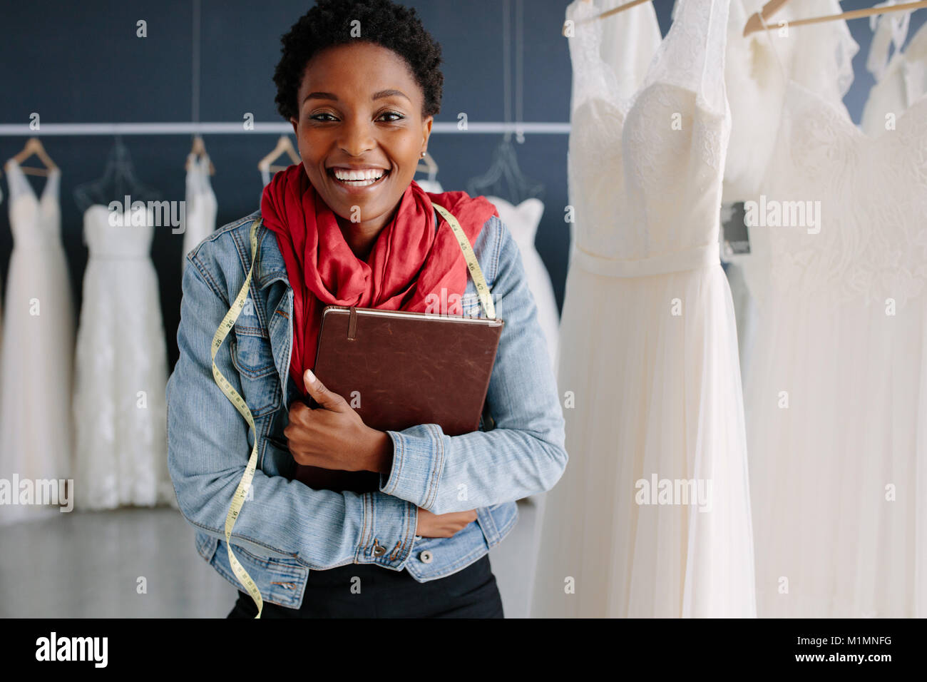 Fröhliche Bridal store Inhaber stehen in Ihrer Boutique mit einem Tagebuch. Weibliche Hochzeit Mode Designer Bridal Boutique. Stockfoto