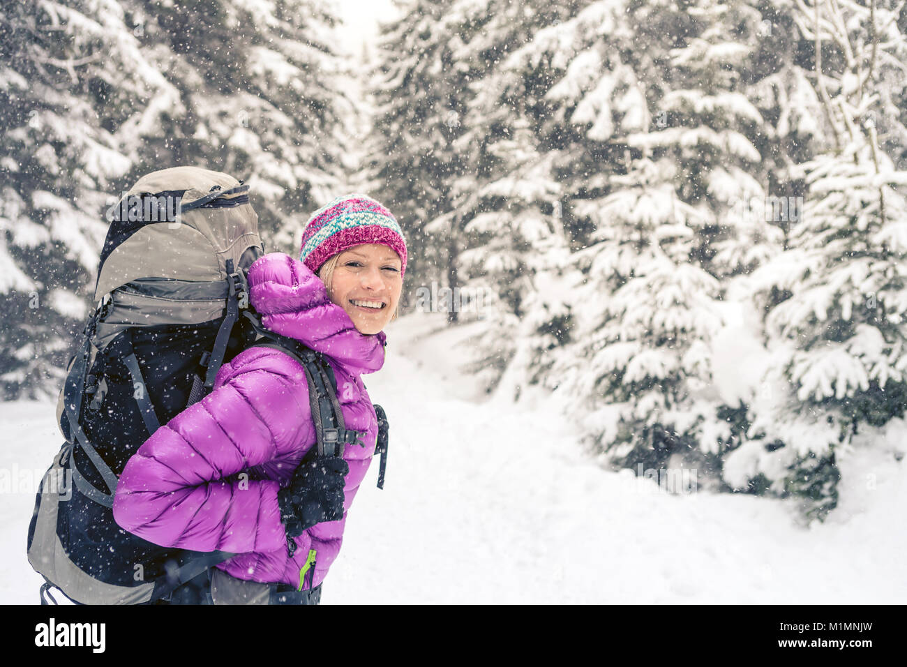 Frau wandern in weiss Winter Forest Woods mit Rucksack. Junge Mädchen zu Fuß auf verschneiten Trail. Erholung Fitness und gesunde Lebensweise, Camping im Freien Stockfoto