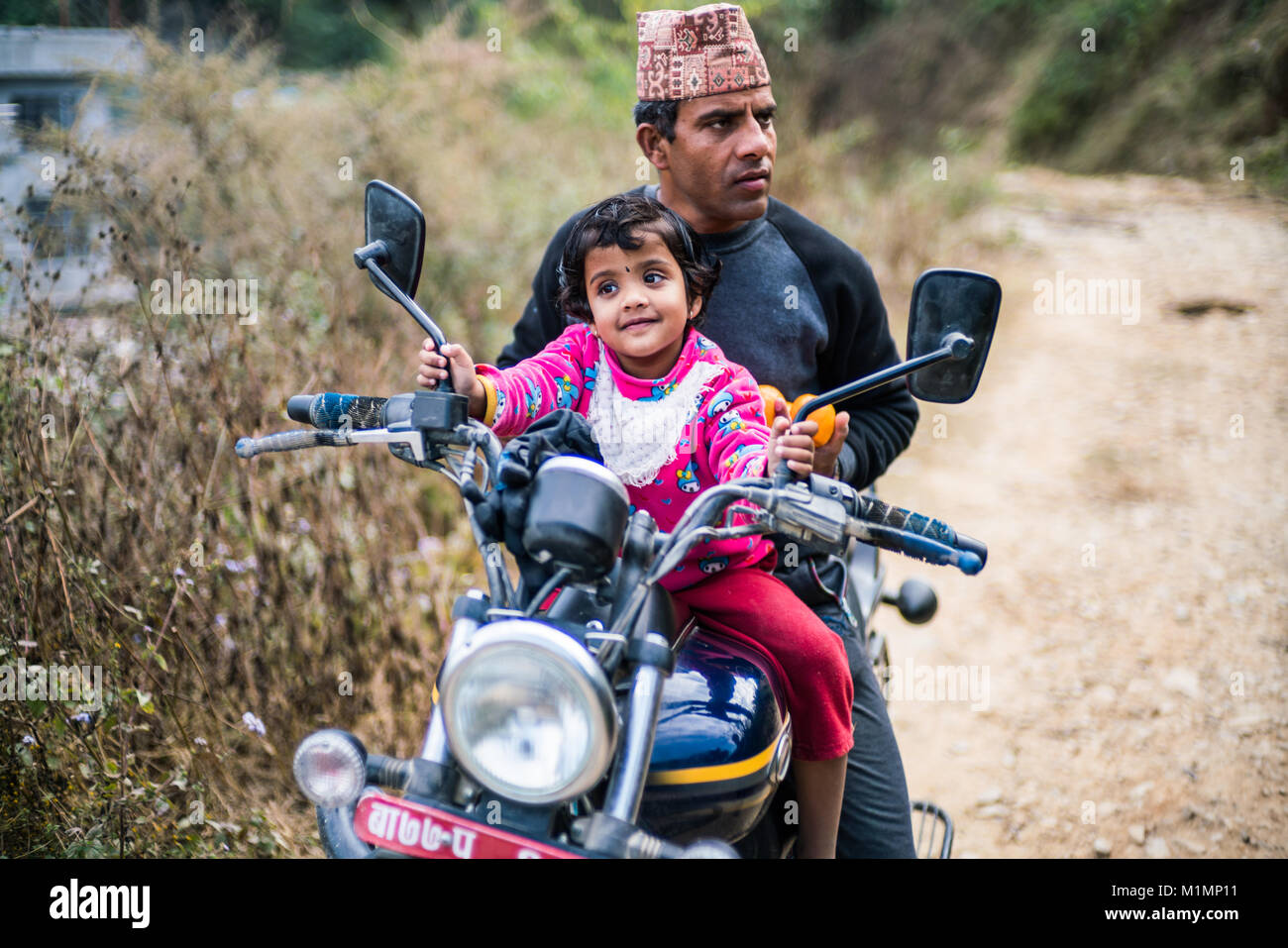 Nepali Mann mit Tochter auf dem Motorrad, Nepal, Asien Stockfoto