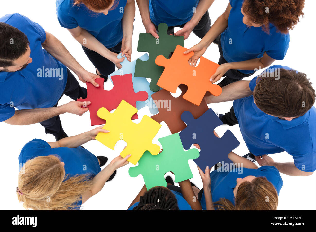 Gruppe der Hausmeister Mit Bunten Puzzle auf weißem Hintergrund Stockfoto