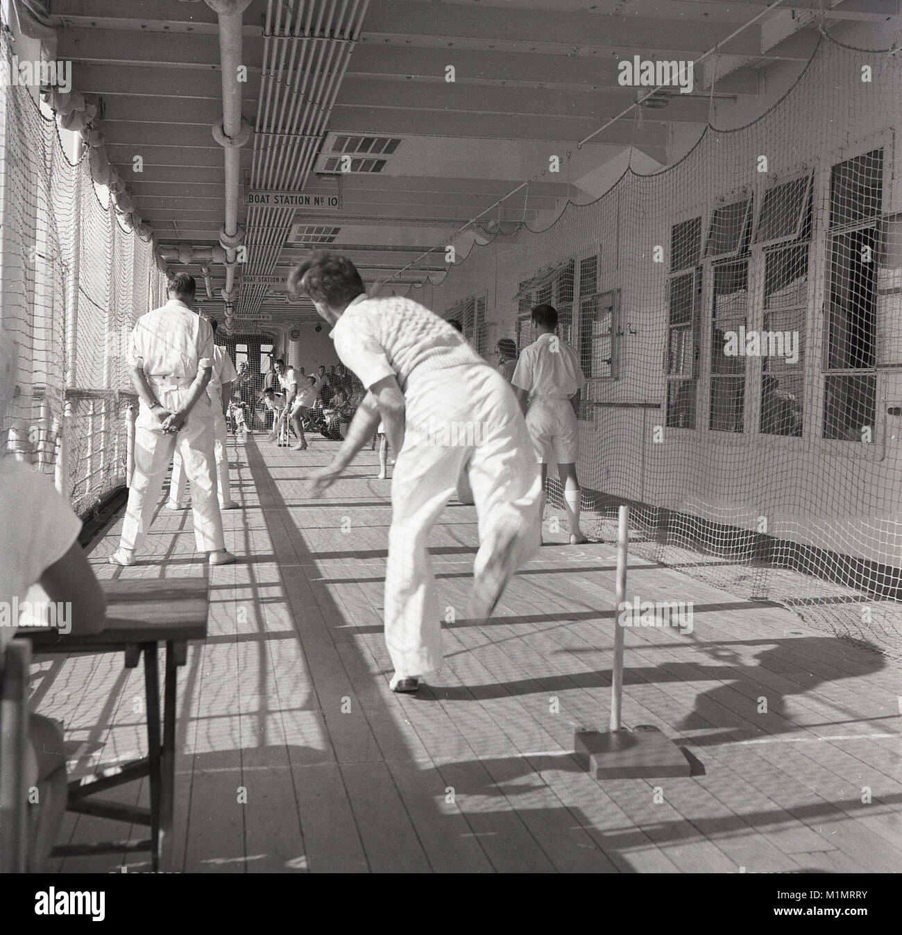 1950, historische, männlichen Passagiere und Mannschaft ein Spiel der deck Cricket. Sie sind auf eine Union - Schloss Steamship, Mail, Güter und Menschen auf eine Seereise zum Kap in Südafrika, das für viele wird es ihr permanentes Zuhause sein, wie Sie beginnen ein neues Leben weg von der Schwermut des nach dem Zweiten Weltkrieg Großbritannien. Stockfoto