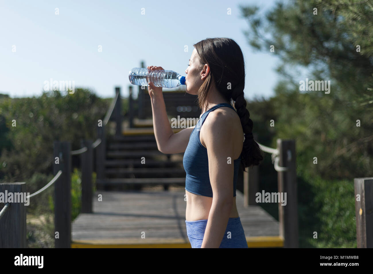 Frau trinkt Wasser aus einer Flasche nach der Ausführung. Außerhalb. Stockfoto