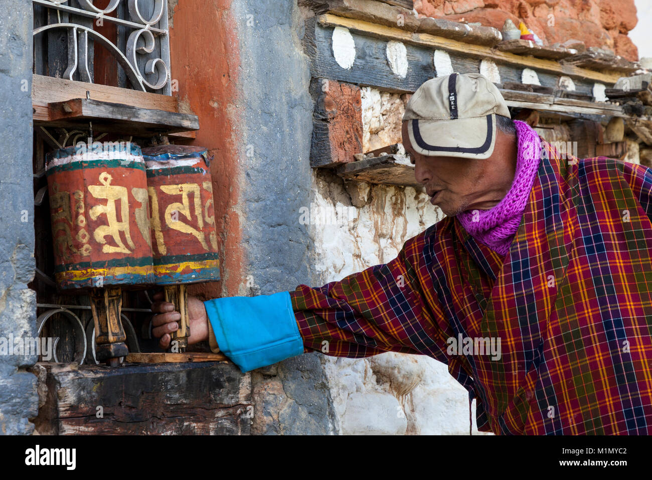 Bumthang, Bhutan. Man Spinnen Gebetsmühlen an Jambey Lhakhang Tempel und Kloster, in der Nähe von jakar. Stockfoto