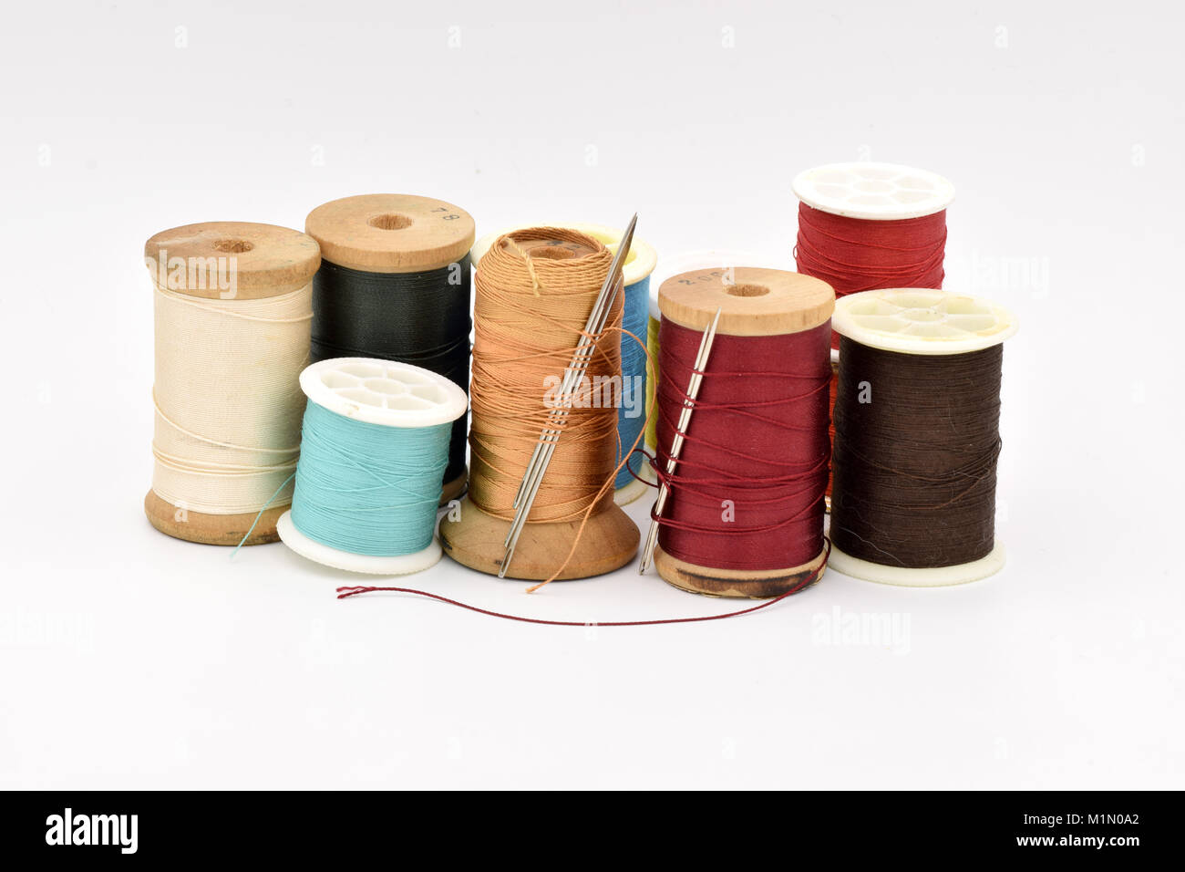 Verschiedene Spulen des bunten Thread auf eine nahtlose weißen Hintergrund angeordnet. Stockfoto
