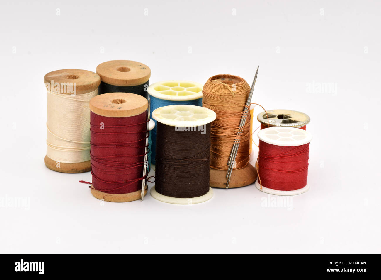 Verschiedene Spulen des bunten Thread auf eine nahtlose weißen Hintergrund angeordnet. Stockfoto