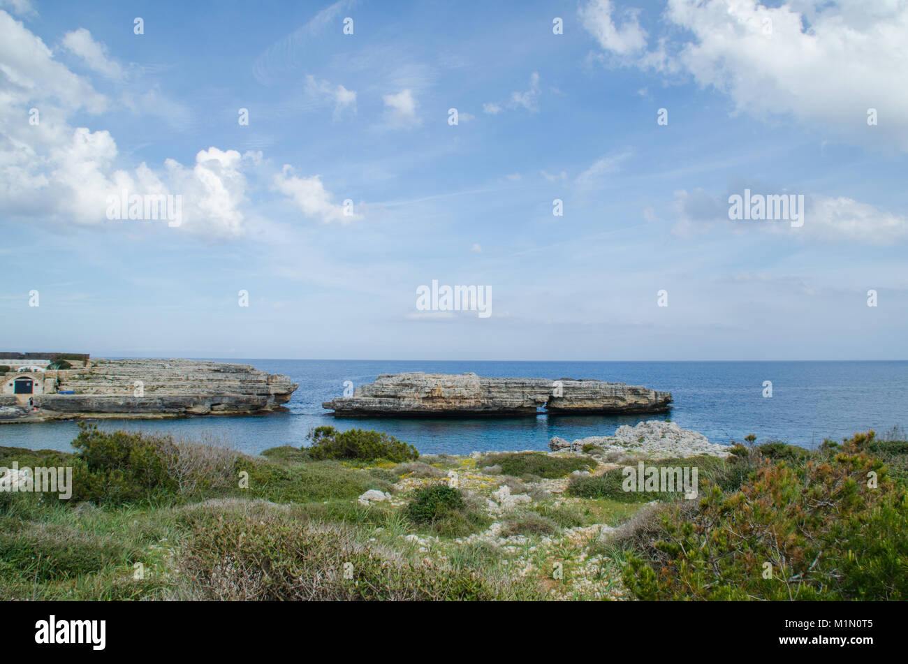 Foto einer Landschaft von Menorca mit eine natürliche Brücke in der Mitte des Meeres. Felsen, Wasser und Pflanzen. Stockfoto
