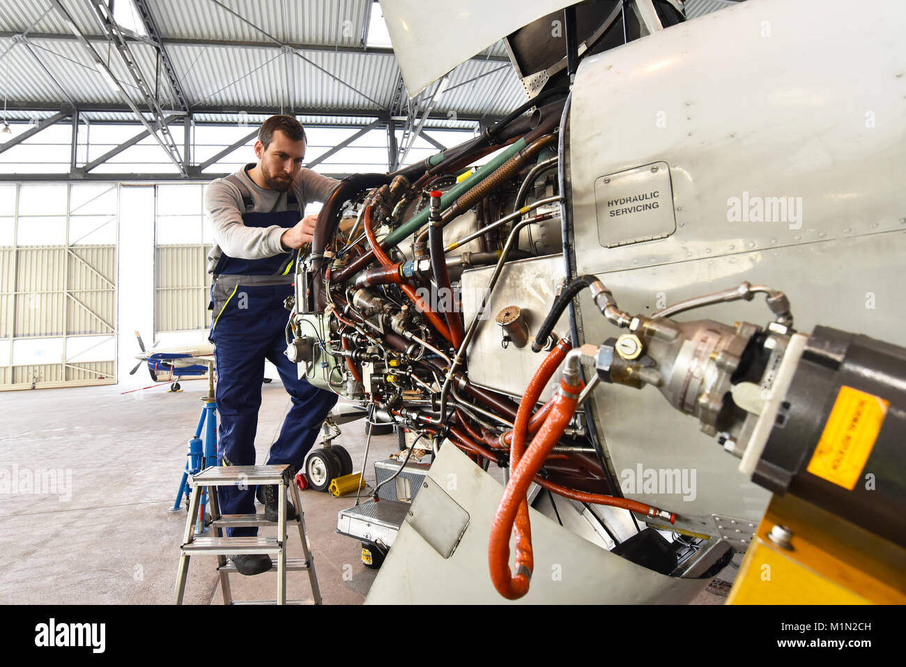 Fluggerätmechaniker Reparaturen Triebwerk in einem Flughafen Hangar Stockfoto