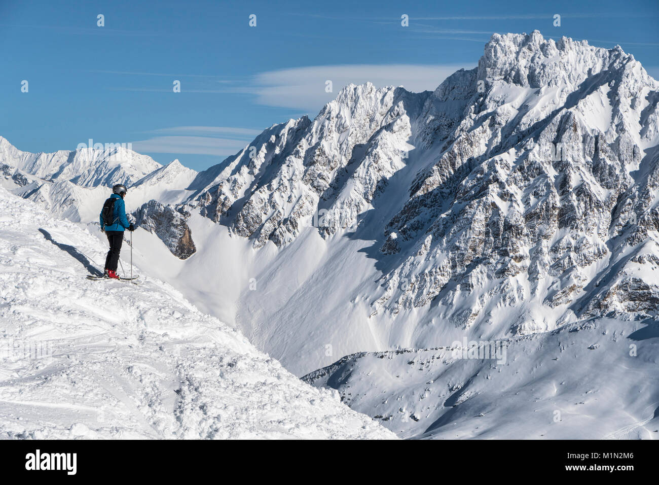 Skifahren off piste in der Nähe von Meribel in die drei Täler Skigebiet in Frankreich. Ein Skifahrer steht an der Spitze eines steilen Schneehang abgedeckt. Stockfoto