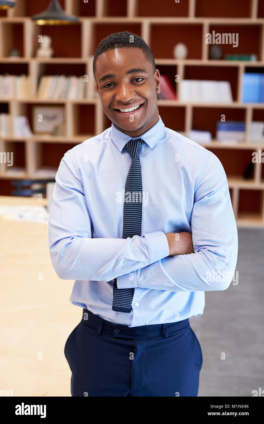 Junge schwarze Mann lächelnd Kamera in einem Sitzungssaal zu, vertikal Stockfoto