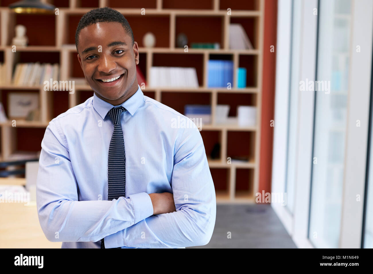 Junge schwarze Geschäftsmann lächelnd in die Kamera in einem Sitzungssaal Stockfoto
