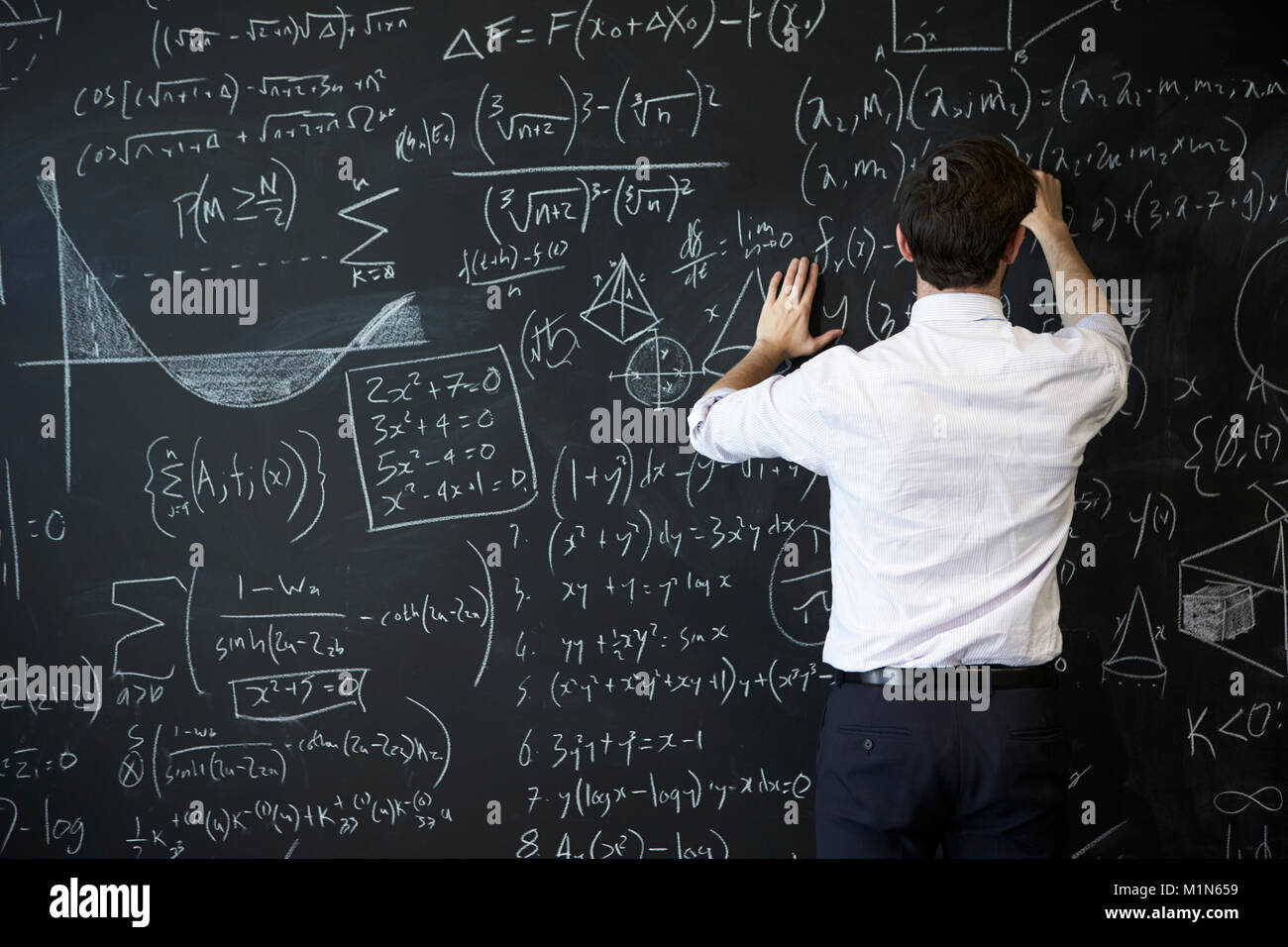 Junger Mann schreiben auf blackboard Stockfoto