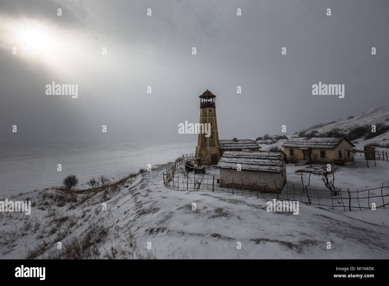 Alten hölzernen Leuchtturm am Rand des gefrorenen Hafen mit bewölktem Himmel Stockfoto