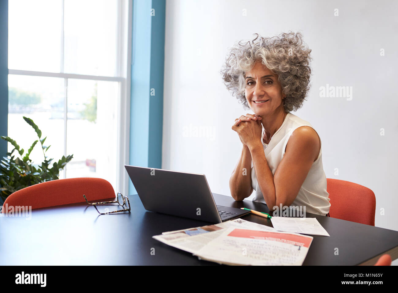 Frau mittleren Alters die Arbeit in einem Büro Lächeln für die Kamera Stockfoto